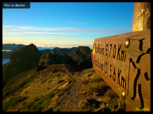 Pico do Areeiro. Photo of sign showing the start of the walk, with mountains and clouds in the background.